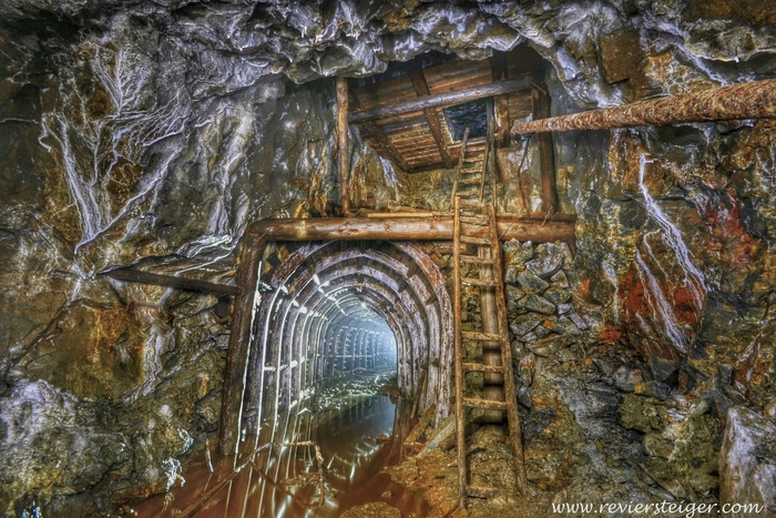 Strecke mit Stahlsegmentausbau und Fahrtenschacht in einem ehemaligen Eisenerzbergwerk